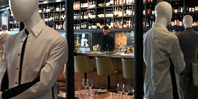 مطعم يعرض الملابس على تماثيل بين الطاولات بهدف البيع والحفاظ على التباعد