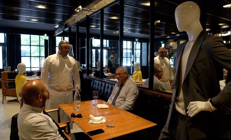 مطعم يعرض الملابس على تماثيل بين الطاولات بهدف البيع والحفاظ على التباعد