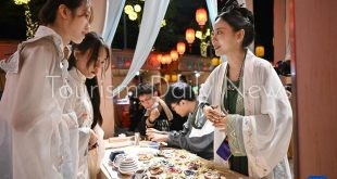 تبيع البضائع في سوق للعادات التقليدية في هايكو بمقاطعة هاينان